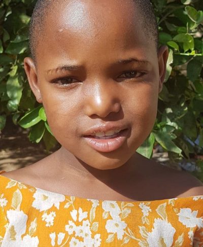 Click Mwajuma's picture to sponsor her - She is 8 years old, loves writing, and wants to be a teacher.